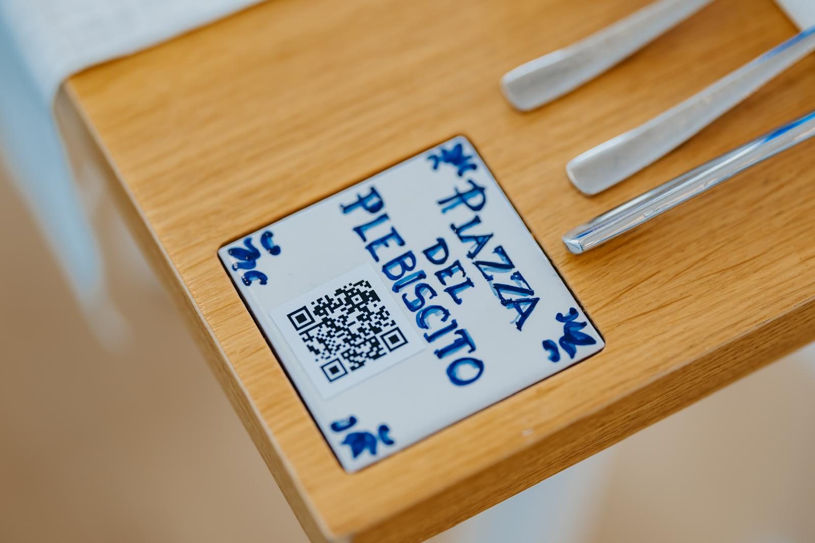 La piastrella «Piazza del Plebiscito», dipinta a mano, con il QR code della pagina dedicata